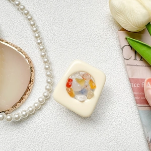 Detail of square phone socket featuring colorful natural gemstones in a cream frame