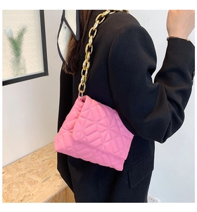 Close-up of quilted pink PU leather shoulder bag with bold gold acrylic chain strap