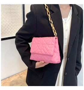 Close-up of pink quilted faux leather shoulder bag with bold gold chunky chain strap