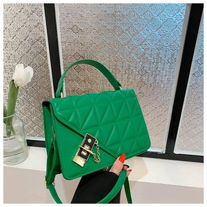 Detail of green leather handbag with geometric quilt pattern and gold-tone buckle closure