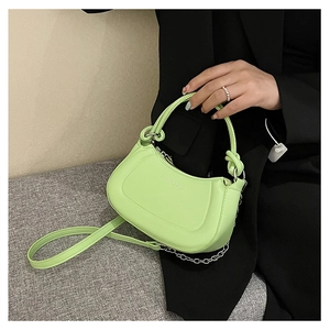 Detail of lime green half-moon bag featuring silver chain and embossed logo decoration