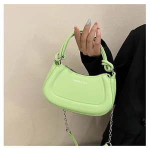 Detail of light green crescent handbag with knotted handle and silver chain strap
