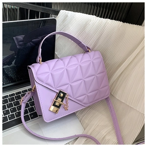 Detail of purple quilted leather handbag featuring a golden square lock and metal chain