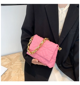 Detail of pink quilted PU leather handbag featuring a chunky gold acrylic chain strap