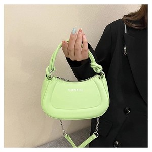 Detail of light green crescent bag with knotted handle and silver chain on model