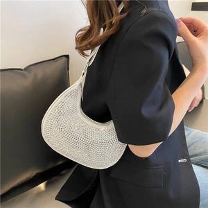 Sparkly white rhinestone crescent underarm bag with silver chain worn by fashion model