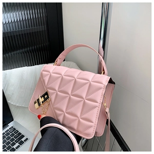 Close-up of pink quilted handbag featuring elegant gold metal lock and chain details