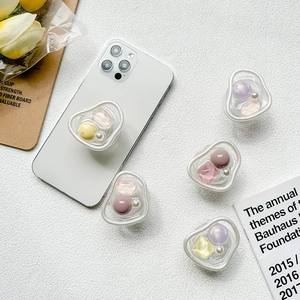 Minimalist resin stone and pearl grip stand for smartphones on textured background