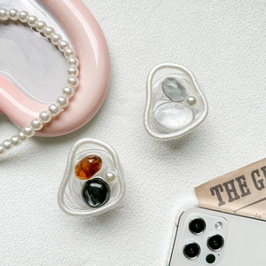 Detailed view of pebble-shaped grip tok with amber resin stones and pearl accents