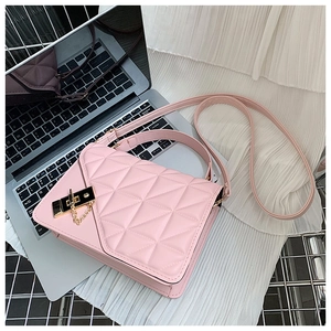 Close-up of pink quilted crossbody bag with gold turn-lock and chain detail on mesh
