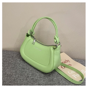 Detail of lime green crescent bag with woven handle and silver metal zipper closure