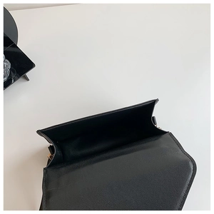 Detail view of the black crossbody bag's spacious interior with dark fabric lining
