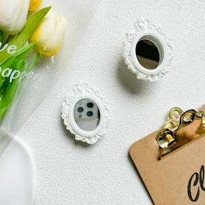 Close-up of vintage white oval relief mirrors with tulips on a textured background
