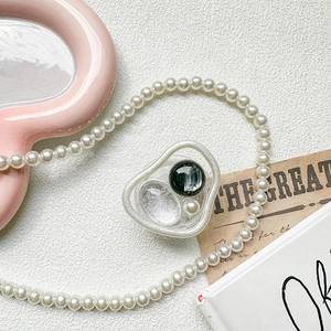Detail view of artistic clear resin phone grip with silver foil and marble bead inlay