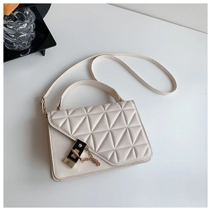 Detail view of the creamy white quilted handbag with golden lock and chain strap hardware