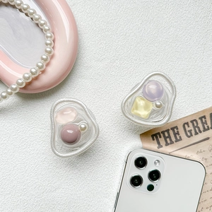 Close-up of heart-shaped resin phone grips with pink beads and faux pearls on white texture