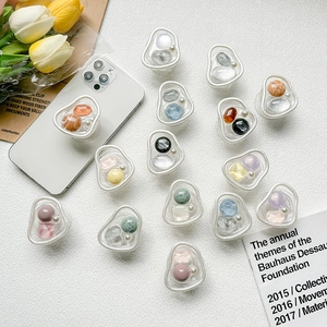 Detailed close-up of resin stone and pearl folding phone grips on a white device