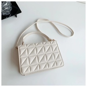 Detailed view of beige crossbody bag with triangle quilted texture and top handle