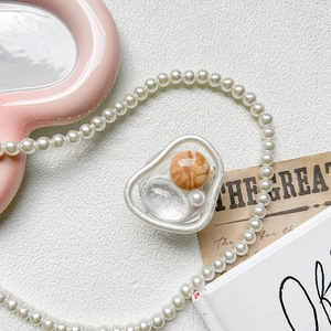 Detail of artistic phone grip with pearl and amber beads in an ins-style setup