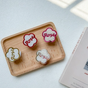 Détail de supports téléphone fleurs avec perles et lettrage Rose sur un plateau
