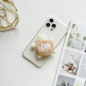 Detail view of cute plush monster phone grip with fuzzy texture and googly eyes