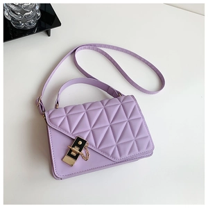Detailed view of lavender handbag featuring geometric quilting and black metal push lock