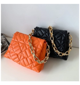 Detail of quilted diamond texture and chunky gold chain on orange and black PU bags