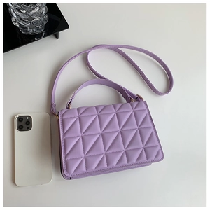 Detail view of lavender quilted crossbody bag next to a smartphone for size reference