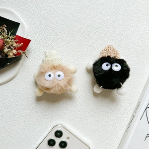 Detail showing plush cartoon monster phone grips in black and khaki with cute knit hats