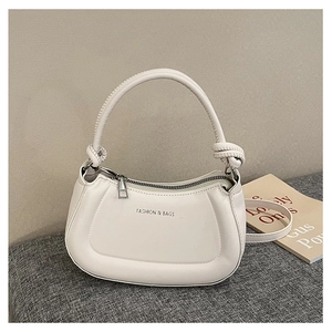 Close-up of minimalist cream PU leather handbag with zipper and knotted handle strap