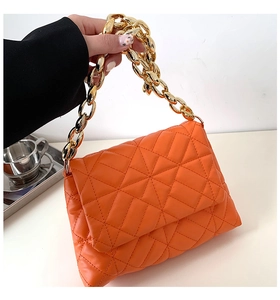 Detail of orange quilted PU leather bag with chunky gold acrylic chain strap