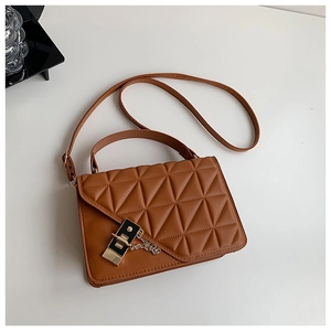 Detailed close-up of brown quilted leather handbag with metal buckle and chain strap