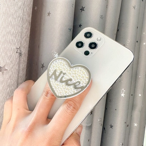 Support de téléphone cœur avec perles et lettrage Nice sur un smartphone blanc