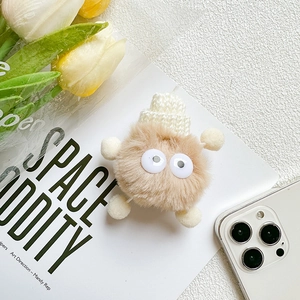 Detailed view of the cute plush monster phone grip featuring fluffy faux fur and knit hat