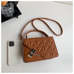 Brown quilted leather shoulder bag with gold clasp and chain detail shown near a phone