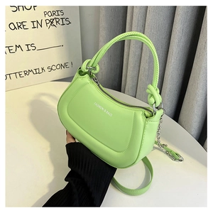 Detailed close-up of lime green half-moon bag with knotted handle and silver chain strap