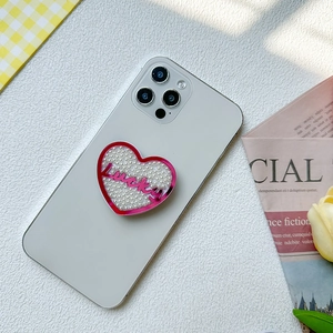Détail du support de téléphone en cœur avec perles et texte Lucky sur smartphone blanc