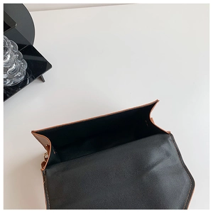 Macro view of brown leather bag showing wide interior opening and black fabric lining