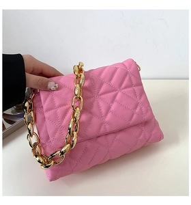 Detail of pink quilted leather handbag featuring a chunky gold metal chain strap