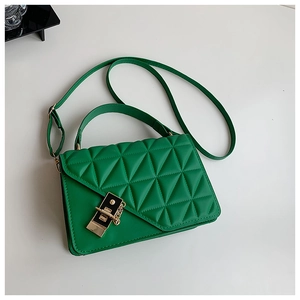 Macro shot of bright green handbag with geometric quilted texture and metal buckle detail