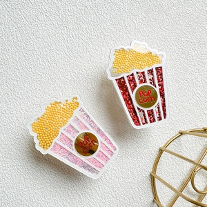 Detail of popcorn-shaped liquid glitter phone socket with Pop Corn text design