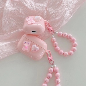 Close-up of pink heart and bear AirPods Pro case with pearlescent beaded wrist strap