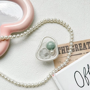 Detail showing resin phone socket with green beads and pearls on aesthetic background