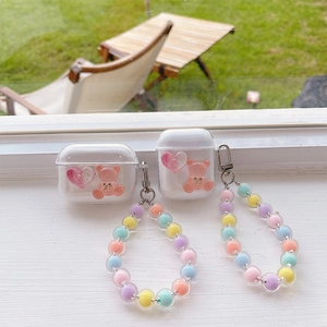 Detailed view of clear AirPods case featuring pink gummy bear and colorful beaded strap