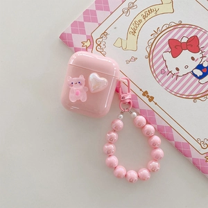 Pink AirPods case detail with cute cat charm and pearly bead wrist strap