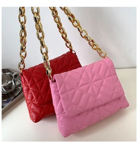 Detail of red and pink quilted PU shoulder bags with bold gold metal chain straps