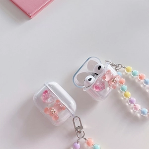 Close-up of clear AirPods case with pink glitter heart, 3D bear, and colorful beaded strap