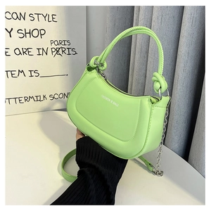Detail of green saddle bag with silver zipper and white FASHION & BAGS lettering
