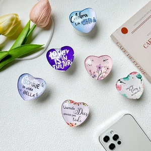 Detail of heart-shaped phone grips with floral designs and inspirational quotes
