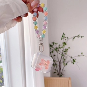 Detailed view of clear AirPods case featuring pink gummy bear and macaron beaded lanyard